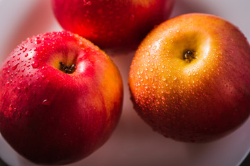 Apple red. Close-up of an apple. Water spray droplets.