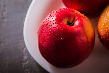 Apple red. Close-up of an apple. Water spray droplets.