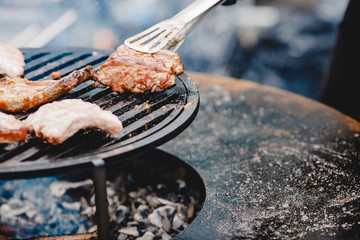 Pork ribs and steak cooked on grill, open fire street food festival
