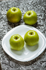 Apples in a plate than a knife. Fresh yellow apples.