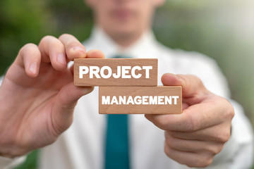 Project Management Business Strategy Concept. Manager combines two wooden blocks with words project and management.