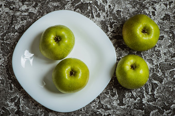 Apples in a plate than a knife. Fresh yellow apples.