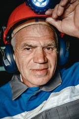 Portrait happy man miner after working in coal mine, dirty face in helmet. Concept vocation...