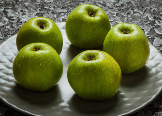 Apples in a plate than a knife. Fresh yellow apples.