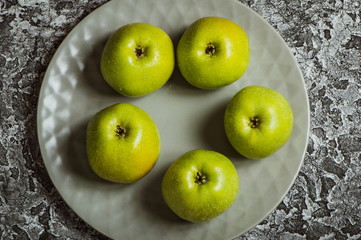Apples in a plate than a knife. Fresh yellow apples.
