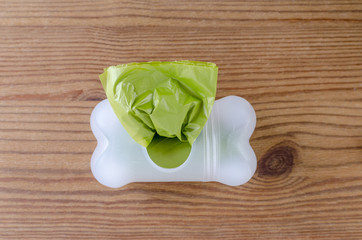 green poop bags on wooden background, closeup