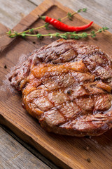 Rib eye steak on wooden board, closeup