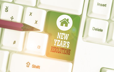 Text sign showing New Year S Resolutions. Business photo showcasing Wishlist List of things to accomplish or improve White pc keyboard with empty note paper above white background key copy space