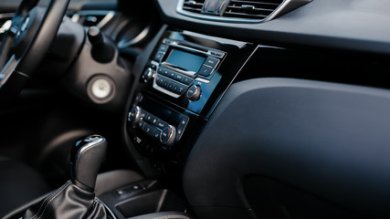 Fototapeta premium Car detailing. Dashboard. Media, climate and navigation control buttons. Sound system. Modern car interior details.