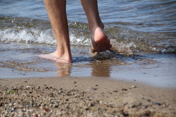 Mann geht am Strand spazieren 