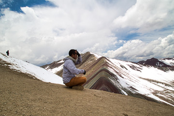 Fototapeta premium Mężczyzna medytuje z panoramicznym widokiem. Scena pieszych wędrówek w Vinicunca, region Cusco, Peru. Montana of Seven Colours, Rainbow Mountain.