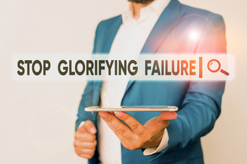 Text sign showing Stop Glorifying Failure. Business photo showcasing do not let Breakdown Rule your life Try again Man in the blue suite and white shirt holds mobile phone in the hand