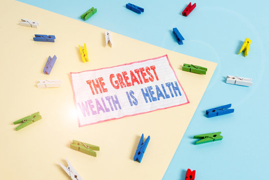 Conceptual hand writing showing The Greatest Wealth Is Health. Concept meaning being in good health is the prize Take care Colored clothespin paper reminder with yellow blue background