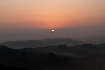 sunrise in a foggy morning - san giminiano tuscany Italy