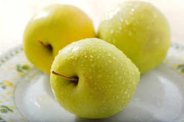 Fresh apples on the table. Sliced apples in a plate.