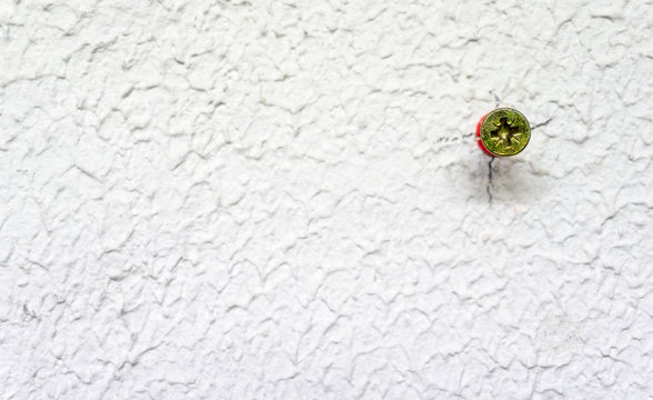 Screw in the wall with red wall plug