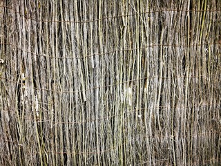 Fence,fencing made from thin stems and twigs. Natural decor. Textured surface