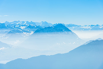 Fototapeta na wymiar Majestic unique misty blue alpine skyline aerial view panorama of iced Swiss Alps and blue sky. Mount Rigi Switzerland.