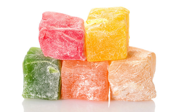 Turkish delight. Different types of rahat locum, five colorful pieces of sweet oriental delights in powered sugar. Close-up macro view.