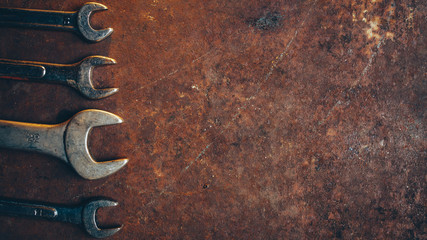 Automobile repair shop. Professional wrench set on rusty dark metal background. Copy space.
