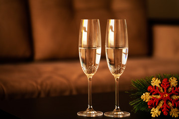 Glasses filled with champagne on Christmas background