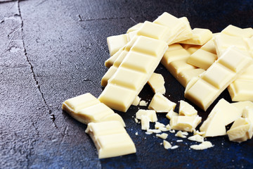 white broken chocolate and cocoa bar. Pieces of white chocolate on rustic background