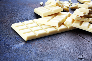 white broken chocolate and cocoa bar. Pieces of white chocolate on rustic background