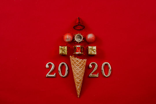Happy New Year 2020. Abstract Christmas tree arrangement in ice cream waffle cone and numbers on maroon background. Copy space.