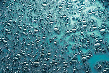 Creative abstract art background. Water drops on blue surface. Bubbled texture effect.