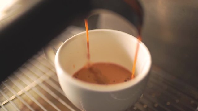 Coffee Maker Pouring Hot Espresso Coffee In A Cup in Slow Motion