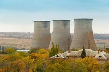 Cooling towers of a power plant. Residential buildings in the foreground. Thermoelectric plant. Overcast autumn day