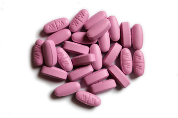 Obraz na płótnie Canvas Pile of pink tablets on white background, isolated. Vitamins or painkillers.