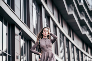 Obraz premium A young girl walks near the office with a handbag on her shoulder