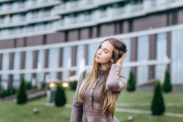 A young girl walks near the office with a handbag on her shoulder