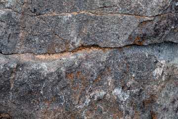 Texture, stone it can be used as a background.  Fragment of a multi-colored stone with scratches and cracks.