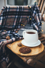 Tea and cookie with festive lights on terrace.