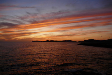 Fototapeta premium Sunset in Alghero, Sardinia, Italy. Capo Cassia in the background.