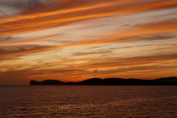 Obraz na płótnie Canvas Sunset in Alghero, Sardinia, Italy. Capo Cassia in the background.
