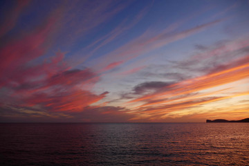 Sunset in Alghero, Sardinia, Italy. Capo Cassia in the background.