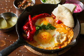 Delicious fresh egg omelet with red chili peppers and herbs in a pan