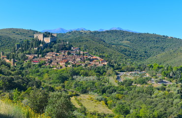 Fototapeta na wymiar One of many charming mountain villages in south of France. Medieval castle, stone walls and family houses on a hilltop surrounded by greenery. Southern Europe 