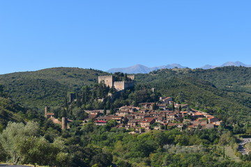 Obraz premium Medieval castle and town situated on a green hill overlooking the mountains. Typical southern European landscape which you find on many post cards and guide books.