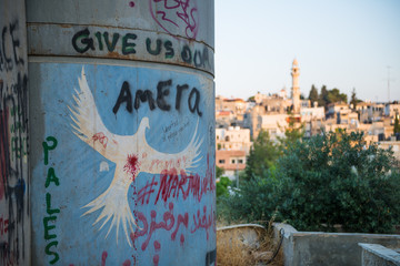 Drawing of a white dove on the Palestinian barrier with view of  Bethlehem, Palestine