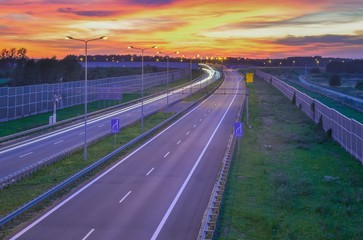 Highway at night. Beautiful colorful sky with the setting light over the A1 highway in Poland.