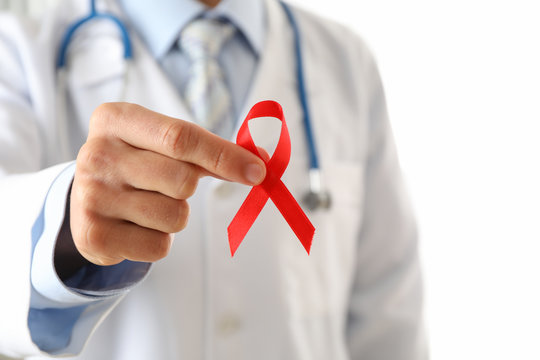 Doctor holds a red ribbon, close up and space for text