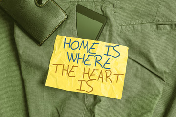 Writing note showing Home Is Where The Heart Is. Business concept for Your house is where you feel comfortable and happy Smartphone device inside trousers front pocket with wallet