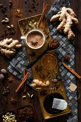 chai tea spices flat lay, chai tea latte with ginger root, cinnamon sticks, cardamom pods, star...