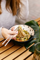 Young european girl eating ramen