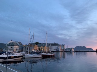 Fototapeta na wymiar Torget - Stadtviertel in Stavanger - Norwegen mit bunten Häuser und Segelschiffe im Hafen, und Abendlicht