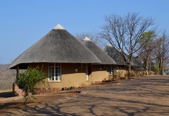 Fototapeta na wymiar Row of thatch roof rondawel huts at the Olifants Rest Camp in Kruger National Park game reserve in South Africa